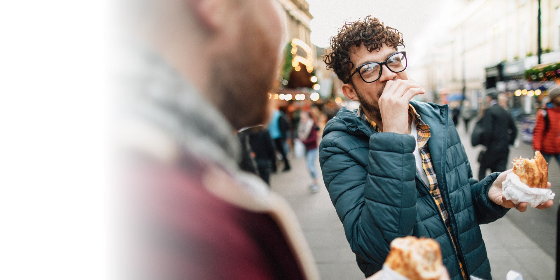 Two friends hanging out together outside eating breakfast