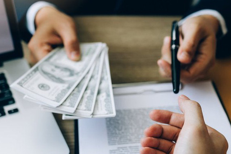 A Banker handing over cash and a pen