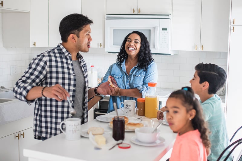 A family in their kitchen eating breakfast