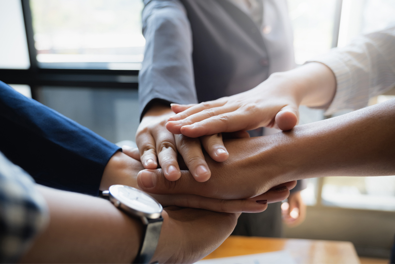 A team putting their hands together for their teamwork this past week