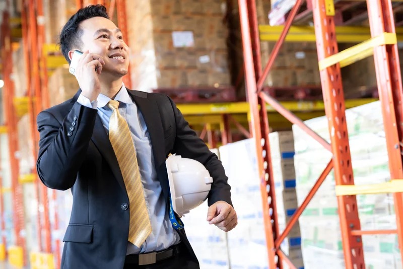 A man taking a call inside his warehouse