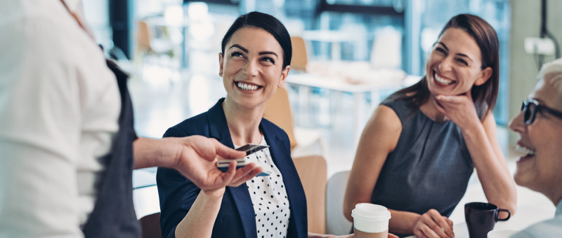 A client handing her card to the vendor