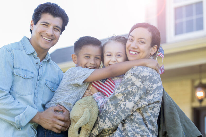 A family welcoming their mom home from service