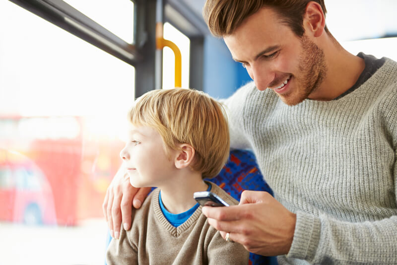 A son with his dad on the bus