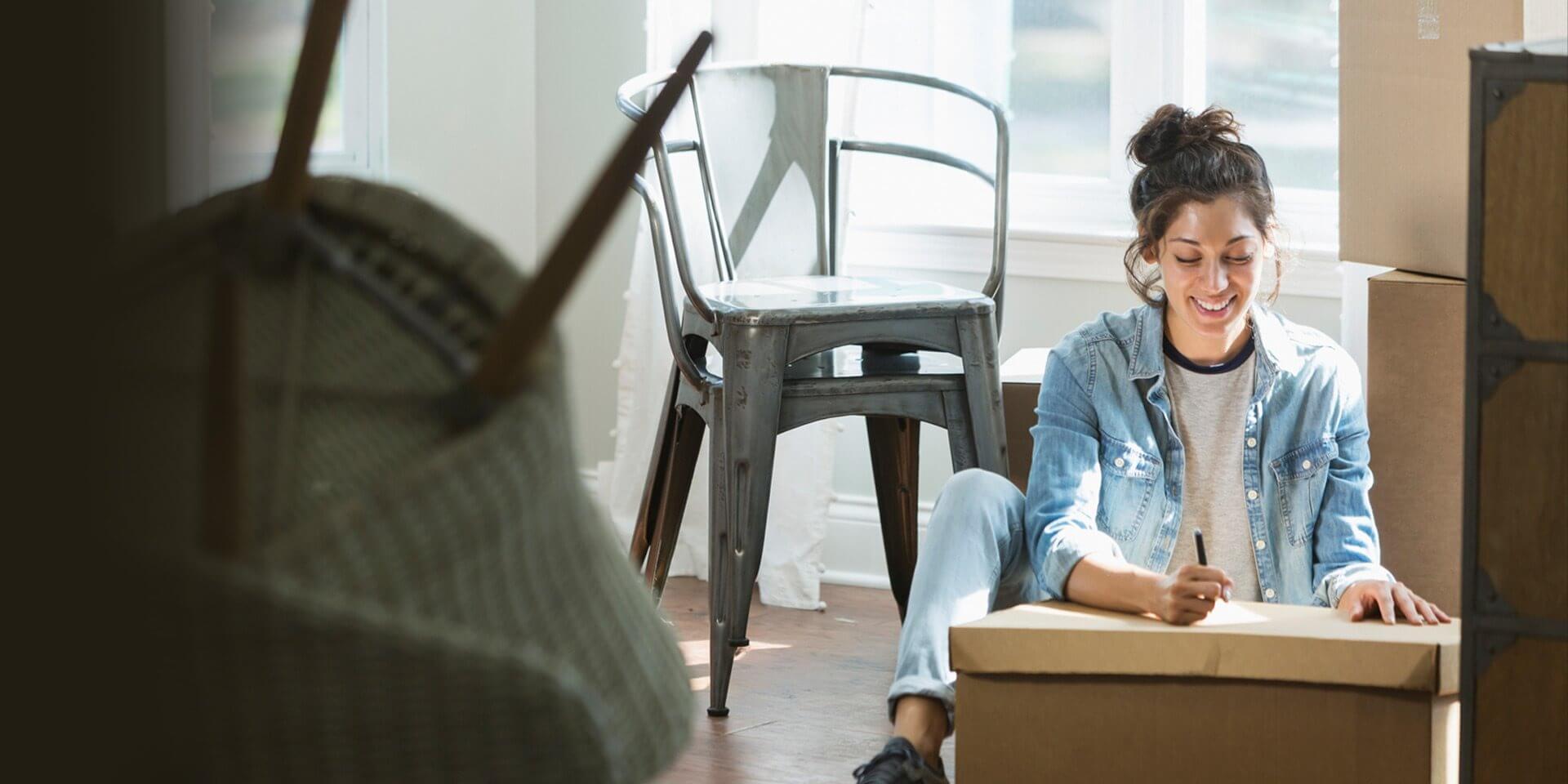 A woman packing up her belongs to move into her new home