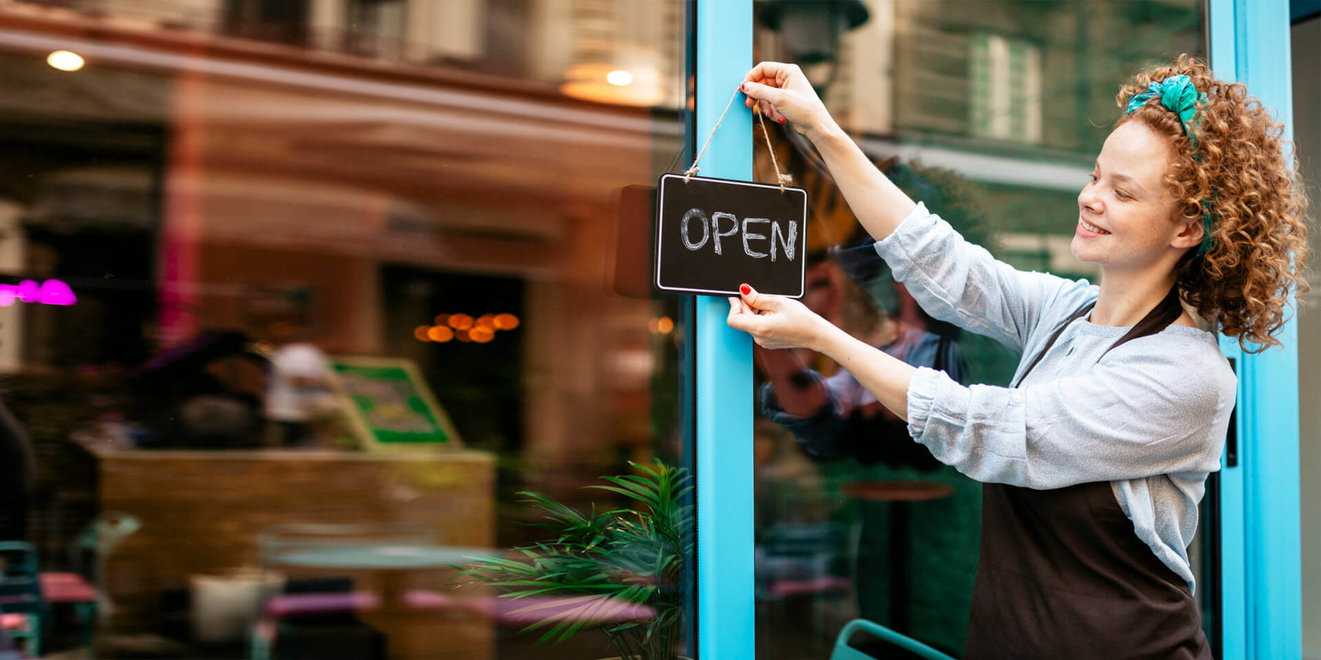 A shop owner opening up her store