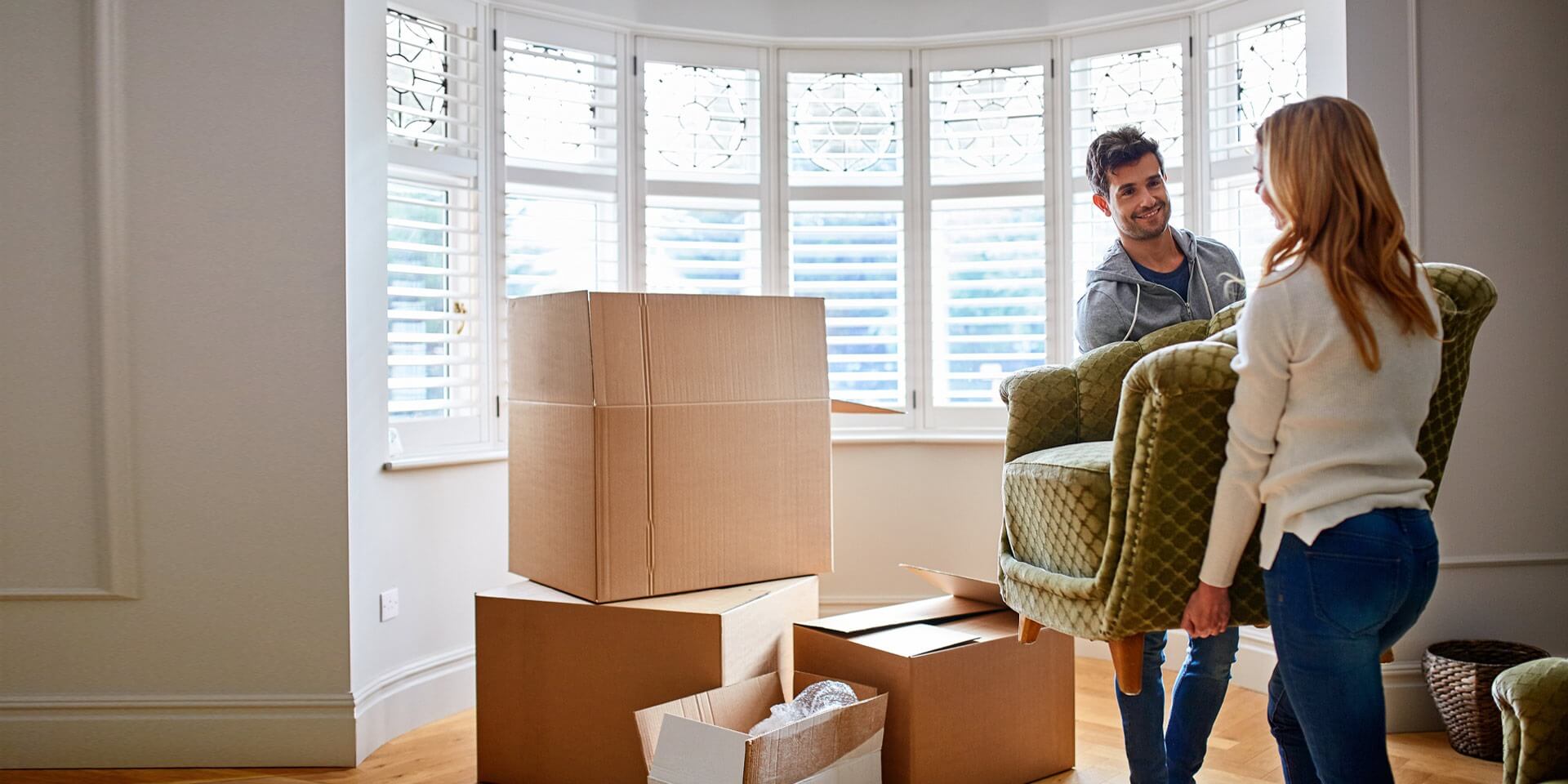 A couple moving furniture in on their new home