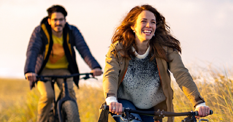 Two people out riding a bike enjoying the weather