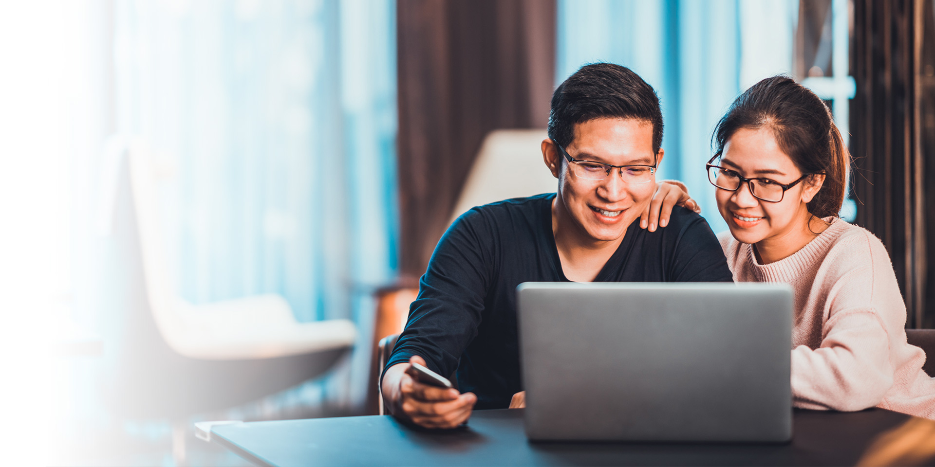 A couple looking for a new savings account online